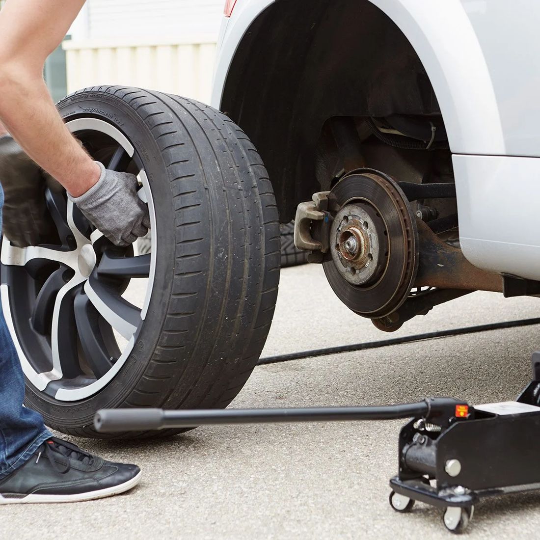 Technician mounting a wheel during a tire change